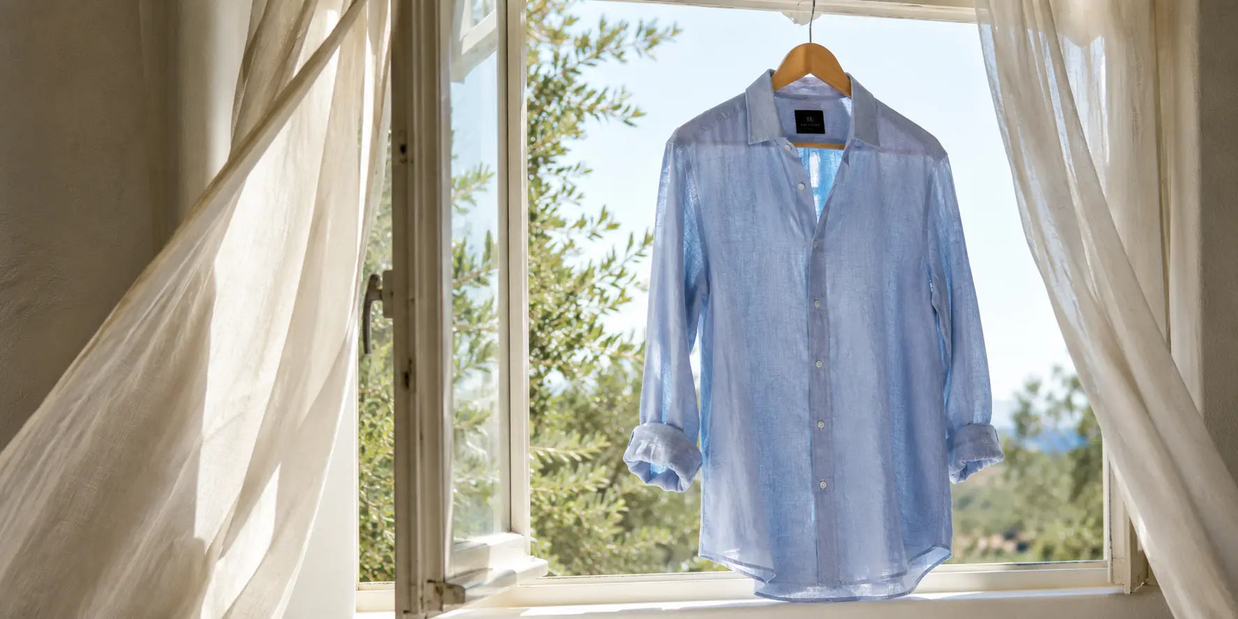 Camisa ligera de verano junto a una ventana abierta con luz natural