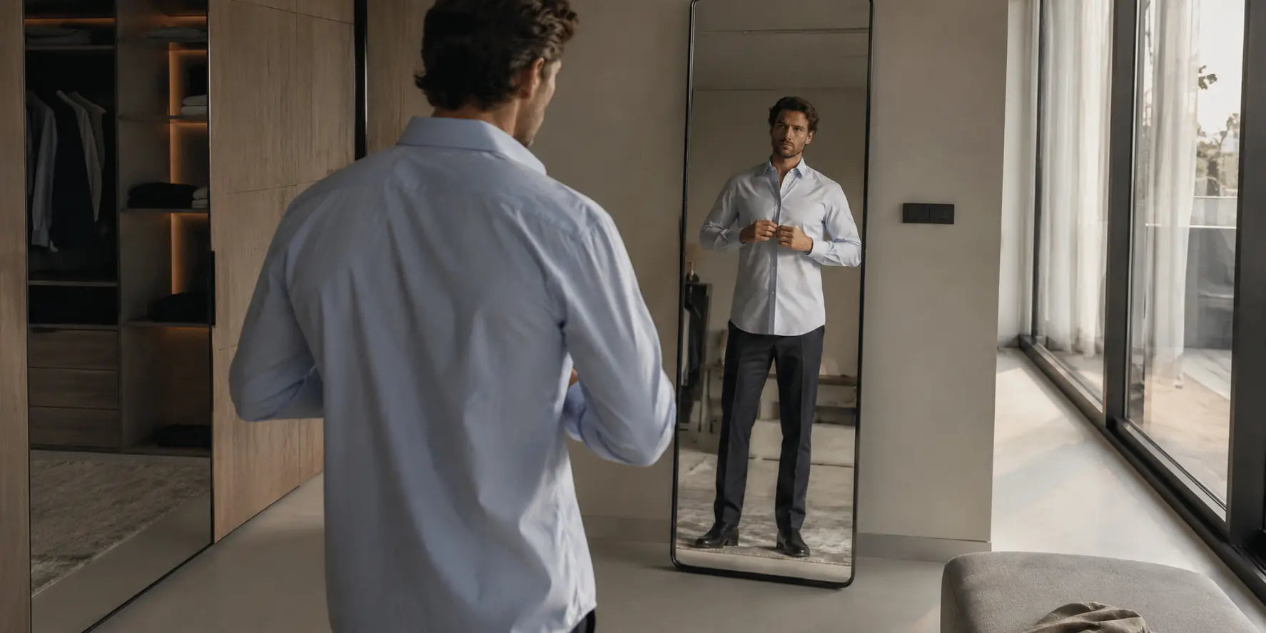 Hombre comprobando el ajuste de una camisa frente al espejo