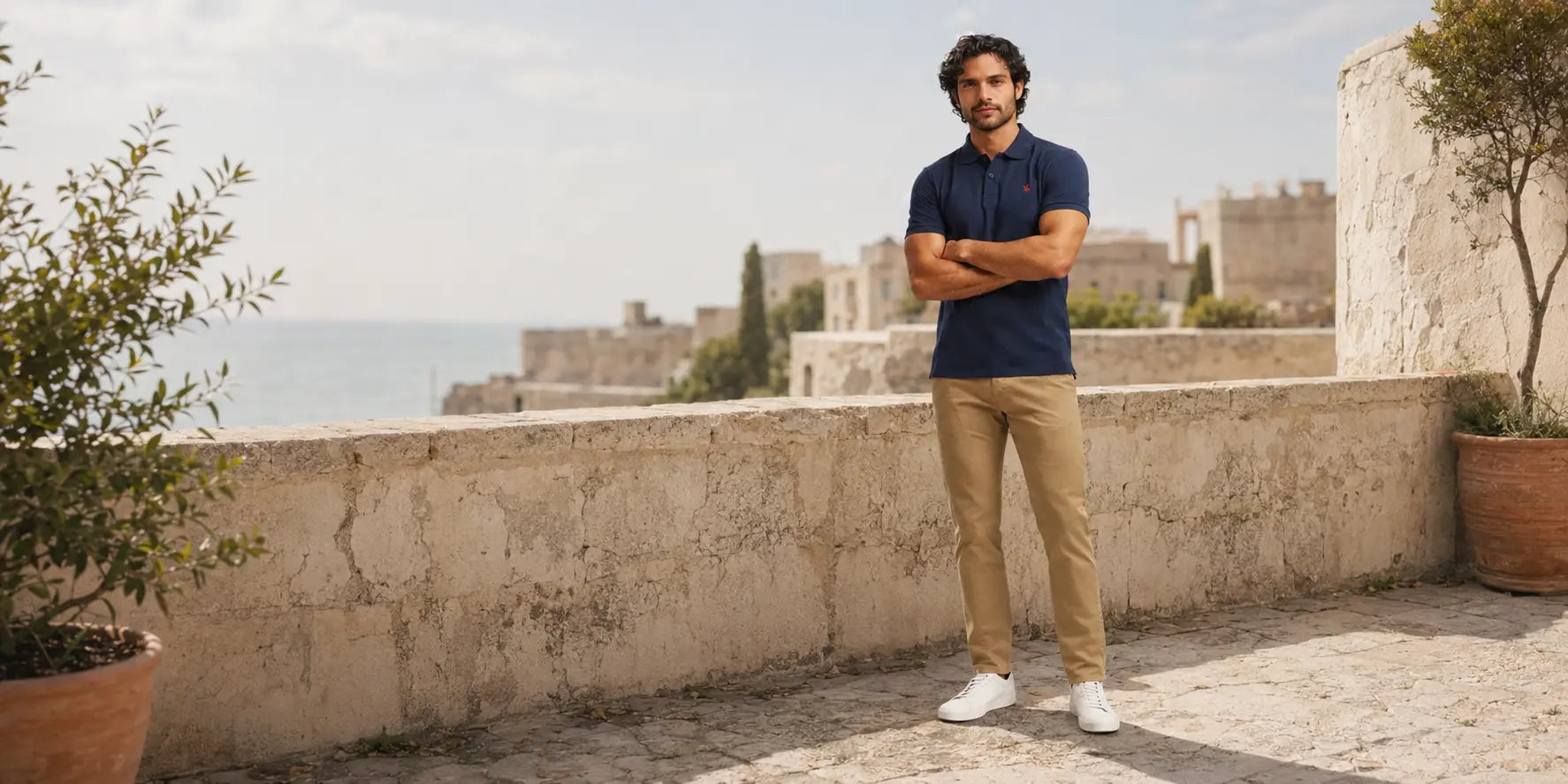 Hombre con polo azul marino y pantalón chino beige en un look cuidado para el día a día