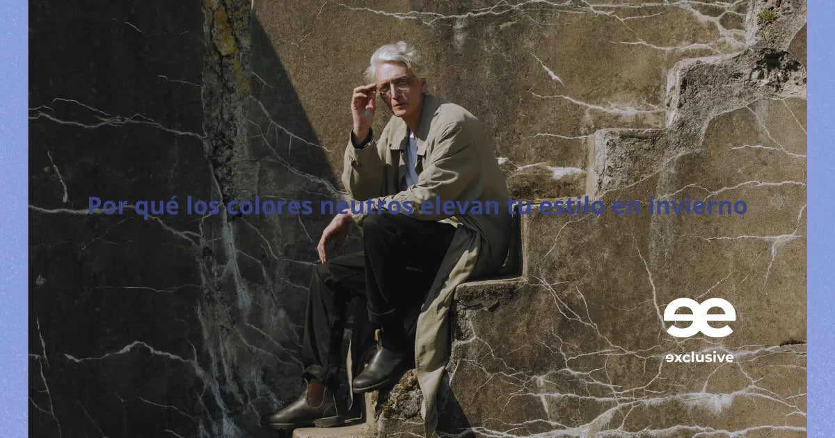 Hombre vestido en tonos neutros sentado en escaleras de piedra durante el invierno.