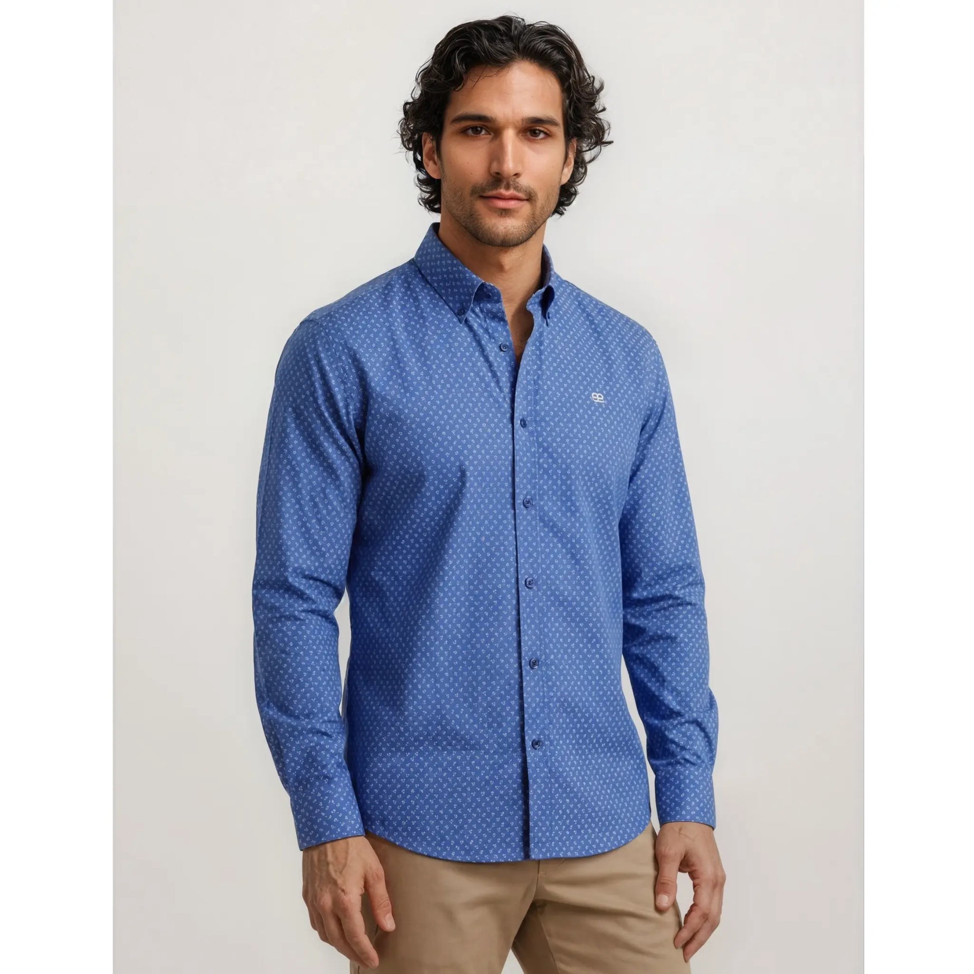 Hombre con camisa azul estampada y pantalón beige en un look elegante y urbano de estilo casual premium