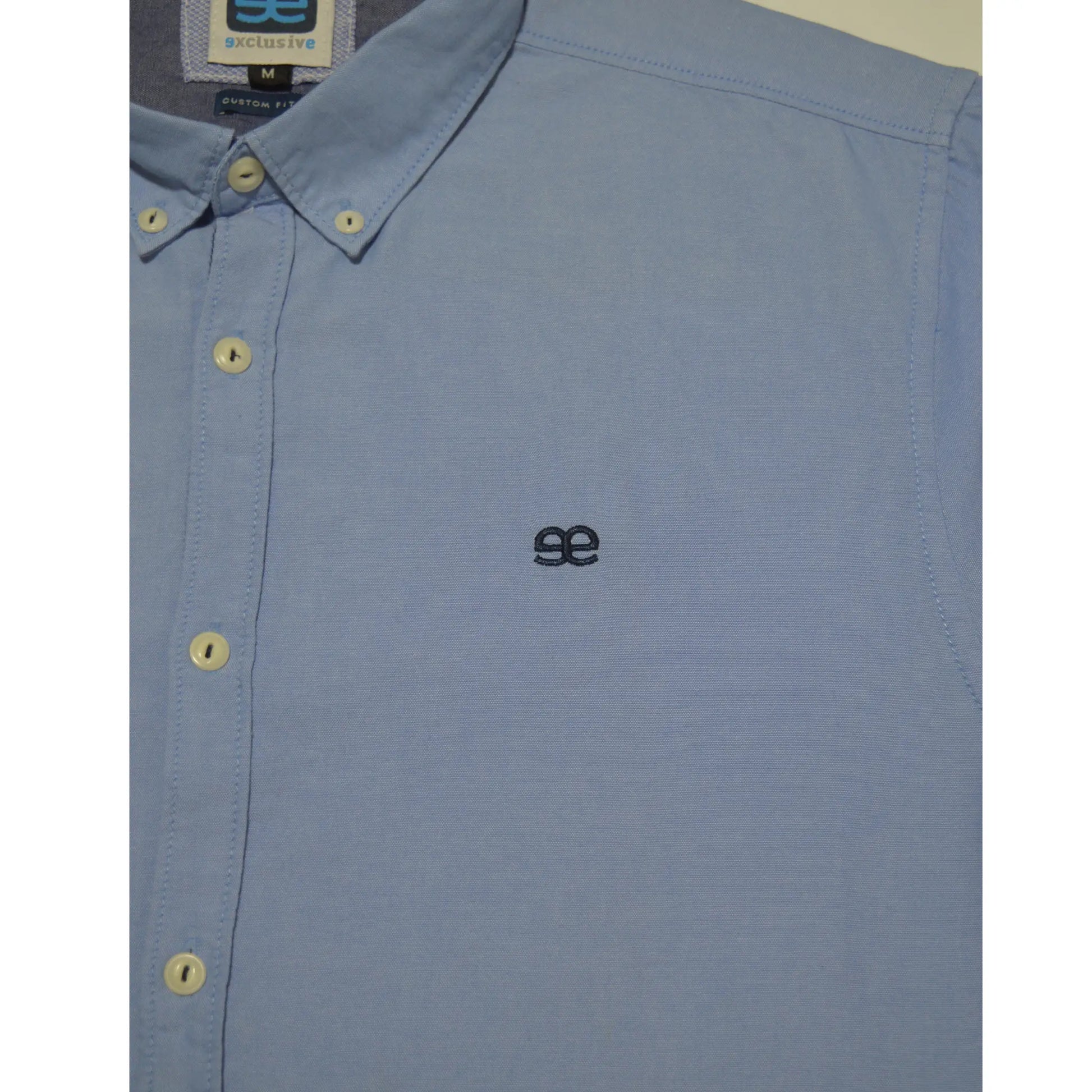 Detalle logo bordado en camisa azul para hombre acabado limpio y discreto con estilo premium