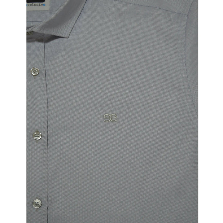 Detalle de camisa azul clara para hombre con tejido texturizado y logo bordado EE Exclusive