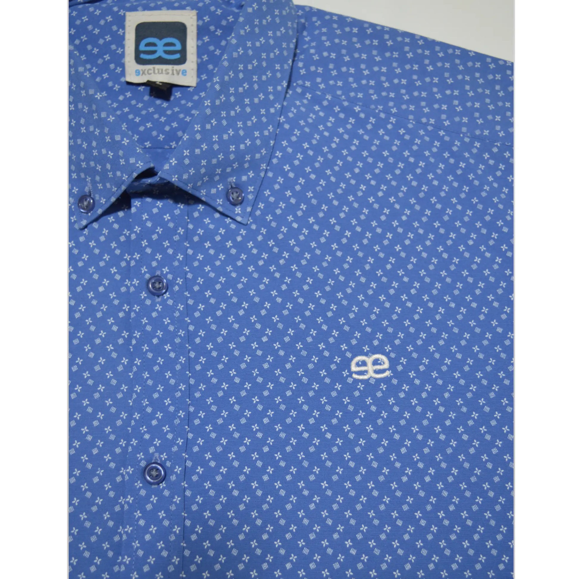 Detalle de camisa azul estampada para hombre con cuello clásico y logo bordado EE Exclusive