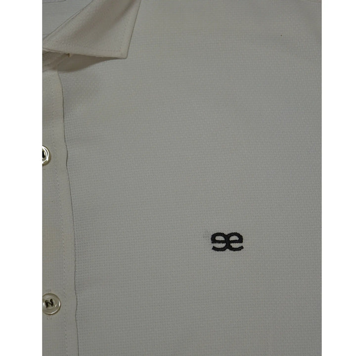 detalle camisa blanca de algodón texturizado con logo bordado en el pecho, acabado premium y tejido de calidad EE Exclusive