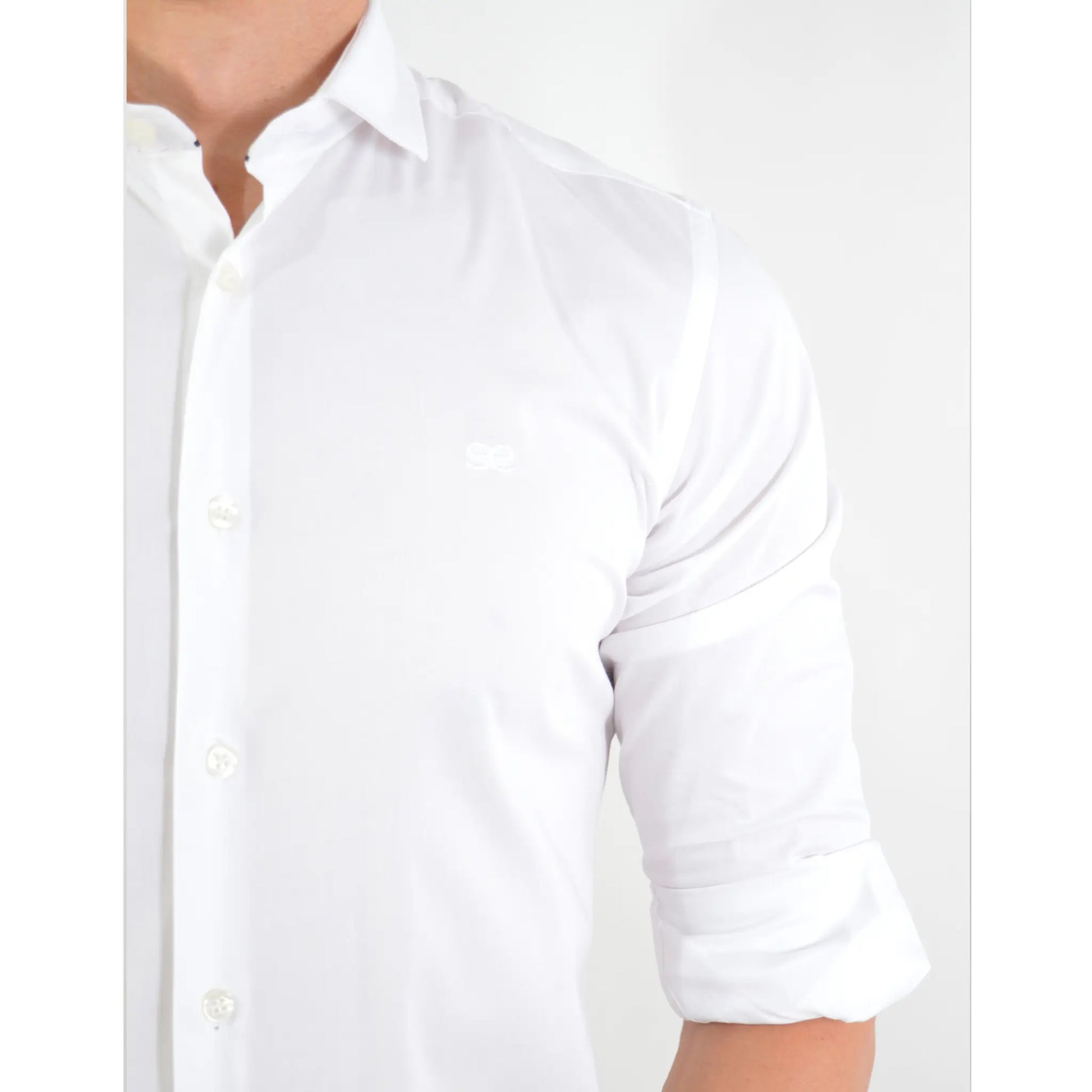 Detalle de camisa blanca para hombre con manga remangada y logo bordado EE Exclusive
