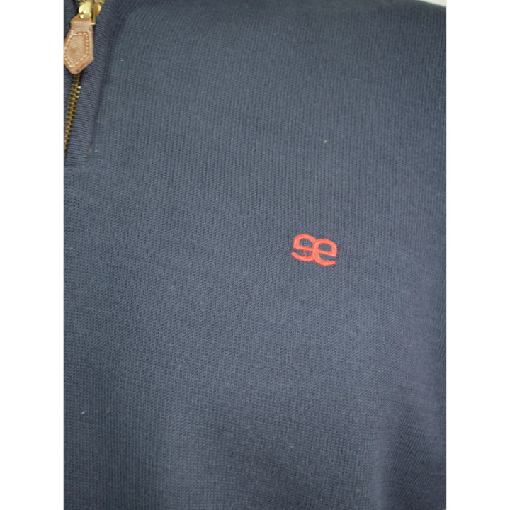 Detalle del tejido y logo bordado del jersey azul marino Kilagi para hombre de EE Exclusive