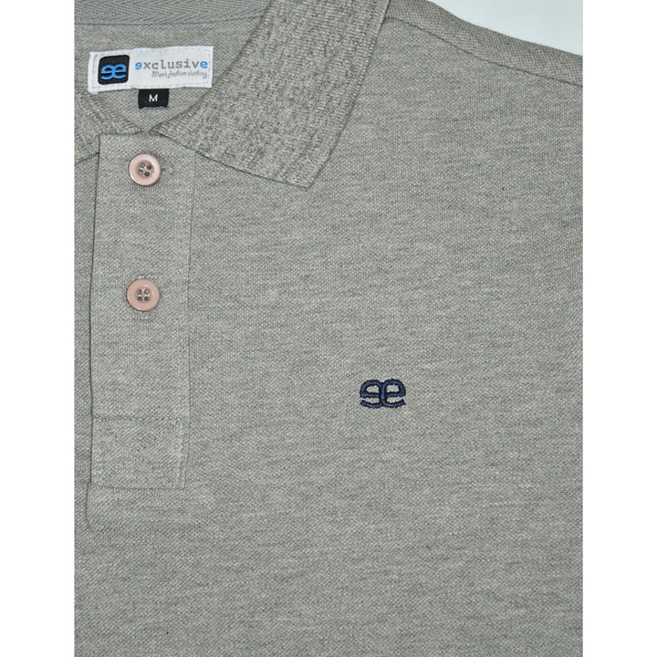 Detalle del logo bordado en polo gris premium para hombre de EE Exclusive