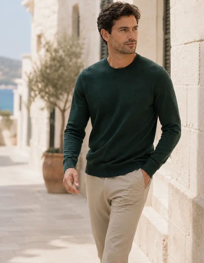 Hombre con jersey verde elegante combinado con pantalón beige en look urbano sofisticado para hombre