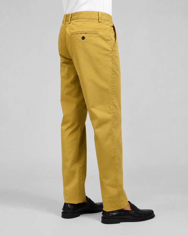 Pantalón chino Albano mostaza para hombre en vista posterior lateral con camisa blanca y mocasines negros