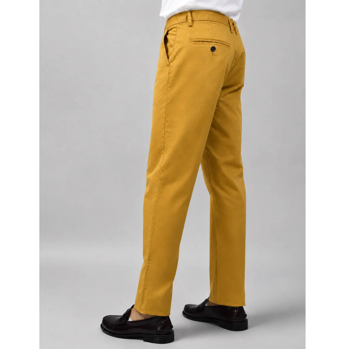 Pantalón chino Albano mostaza para hombre visto por detrás con camisa blanca y mocasines negros