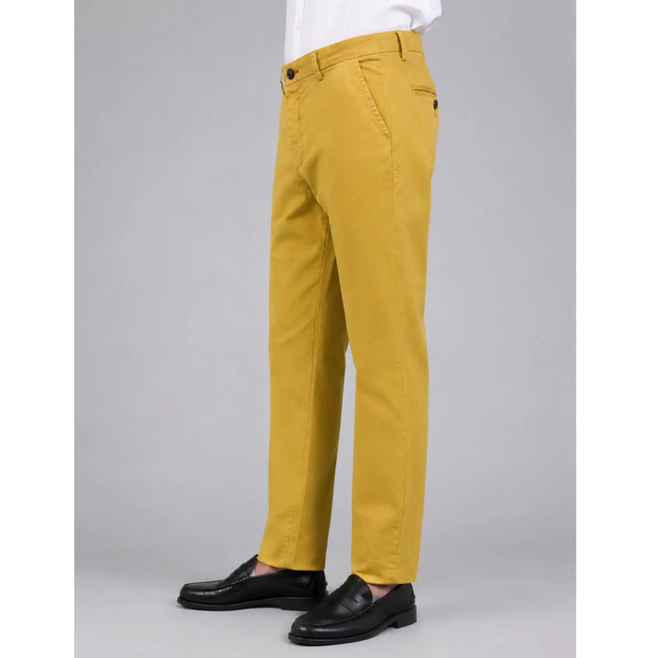 Pantalón chino Albano mostaza para hombre en vista tres cuartos con camisa blanca y mocasines negros