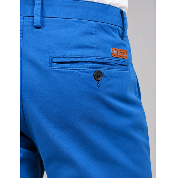 Detalle del bolsillo trasero con botón y etiqueta del pantalón chino azul Albano.