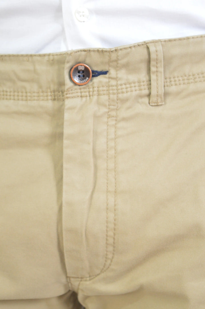 Detalle del botón y cierre del pantalón chino Ginebre EE Exclusive, acabado cuidado.