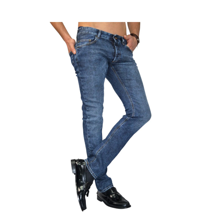 Pantalón vaquero Rocco para hombre en color azul, vista frontal posado con pierna cruzada.
