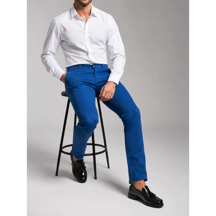 Pantalón vaquero azul Adelpho para hombre EE Exclusive en imagen sentado con camisa blanca y mocasines negros.