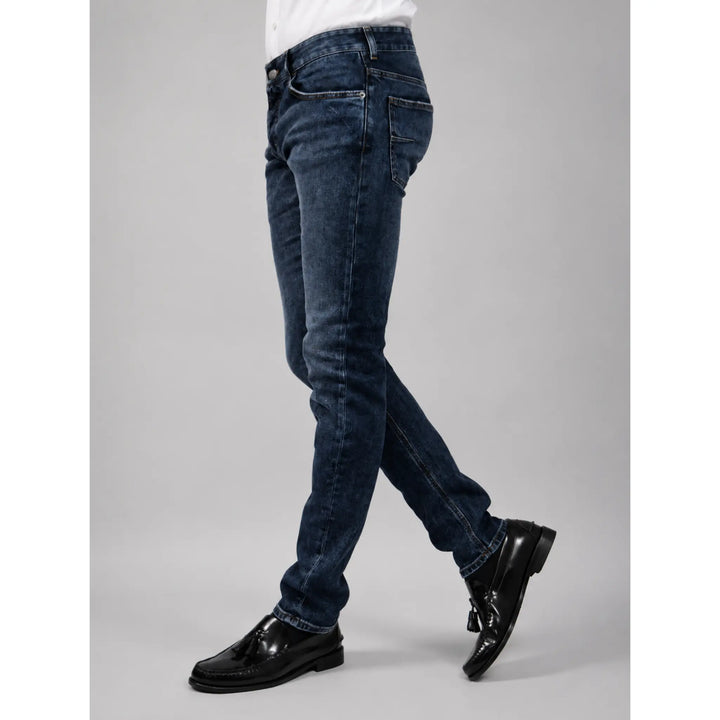 Vista lateral del pantalón vaquero Rocco azul para hombre con mocasines negros