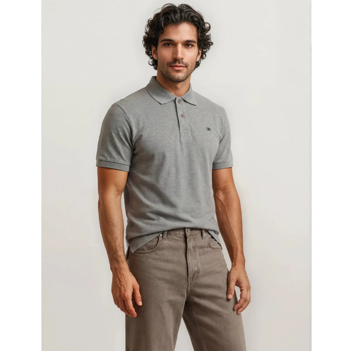 Hombre con polo gris premium de manga corta y pantalón beige en un look masculino elegante y minimalista