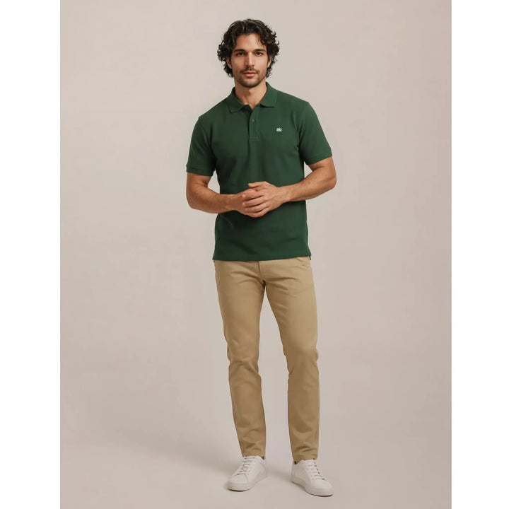 Polo verde de hombre combinado con pantalón beige y zapatillas blancas, ideal para un look cómodo, limpio y con estilo.