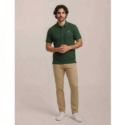 Polo verde de hombre combinado con pantalón beige y zapatillas blancas, ideal para un look cómodo, limpio y con estilo.
