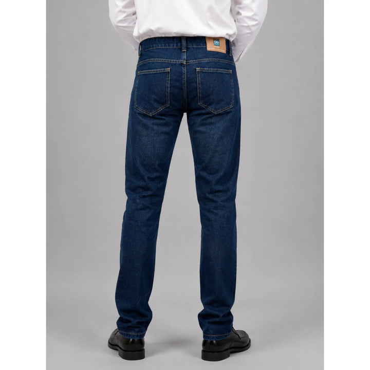 Vista lateral del vaquero recto azul para hombre Ubay con camisa blanca